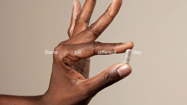 Hand holding a pill with text 'Same pill, different day' on a beige background